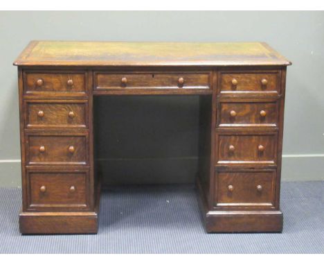 A late Victorian oak twin pedestal writing desk stamped "1209 Wilkinson &amp; Son 8 Old Bond Street" the gilt tooled leather 