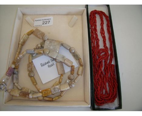 Cased polished sea coral and fossil necklace and a multi-strand coral necklace (2) 
