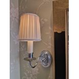 A pair of polished chrome single arm candle stick wall sconces with ovoid decorative backplate