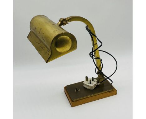An adjustable brass bankers lamp on wooden base