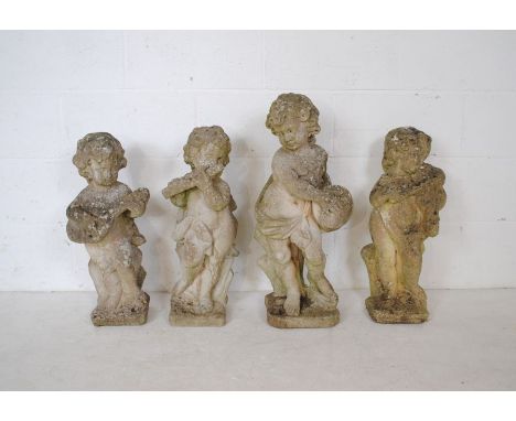 A set of four reconstituted stone garden figures in the form of cherubs playing musical instruments