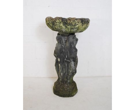 A weathered reconstituted stone garden pedestal planter raised on a plinth in the form of the three graces - height 83cm