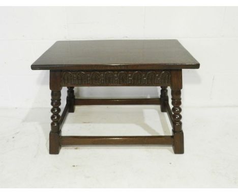 An oak coffee table with carved decoration and bobbin turned legs