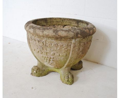 A large reconstituted stone garden planter raised on lion claw feet - diameter 60cm, height 47cm