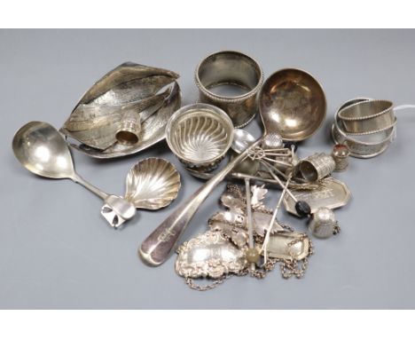 A group of assorted small silver and plated items including caddy spoons, napkin rings, thimbles, wine labels etc.