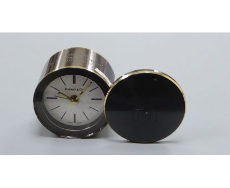 A Tiffany &amp; Co gun metal grey metal promotional travel alarm clock with brass banding Diameter 6cm