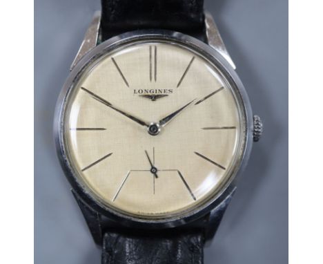 A gentleman's stainless steel Longines manual wind wrist watch, with baton numerals and subsidiary seconds, on associated str