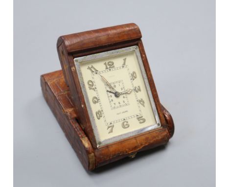 A Jaeger travelling alarm clock with faux crocodile case, the dial with central alarm dial