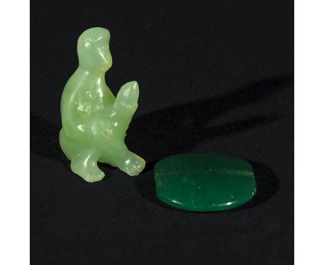 A small jade carving of a monkey and a jade pendant