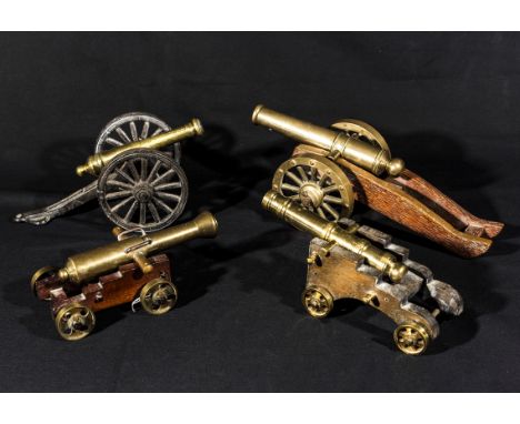A collection of four vintage bronze cannons on wood carriages