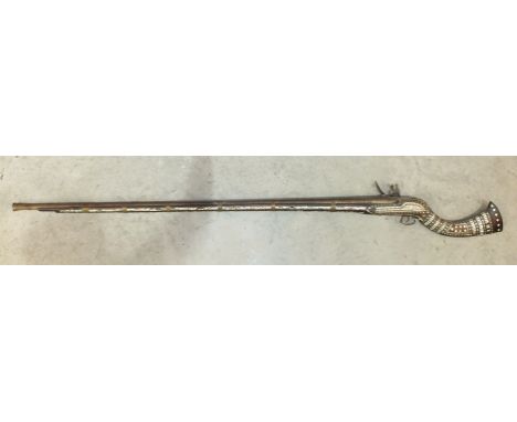 A 19th/20th century Afghan flintlock Jazeel rifle, the 127cm barrel with fullstock inlaid with brass and mother-of-pearl, 171