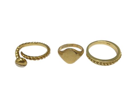 18ct gold ring in the form of a screw, size O½, 18ct gold signet ring, size I and an 18ct gold ring with beaded decoration, s