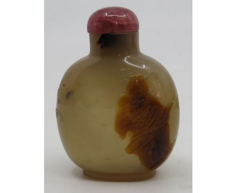 A Chinese russet and green jade snuff bottle carved in relief with two figures, domed stopper, 8cm long
