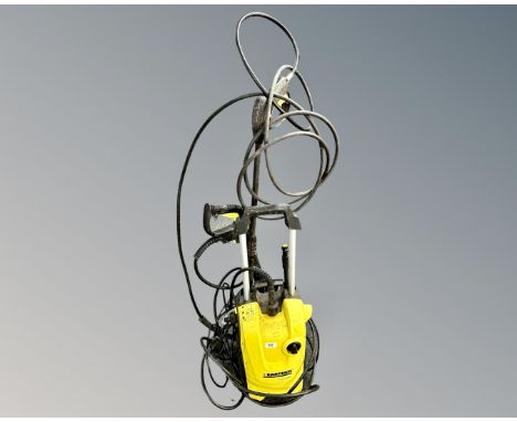 A Karcher K4 compact pressure washer with hoses.