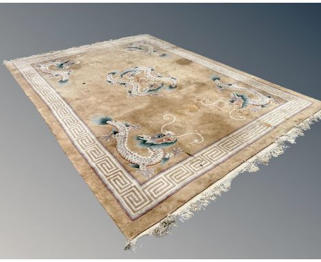 A Chinese carpet with dragon decoration on cream ground, 279cm by 380cm. CONDITION REPORT: Some parts stained.