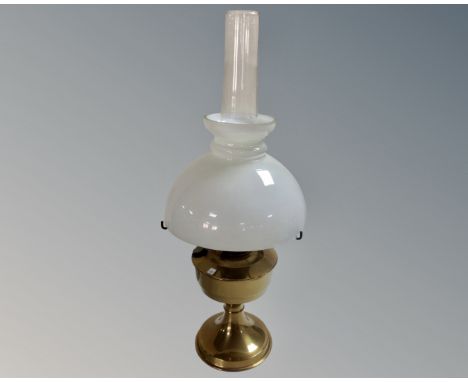 A brass Aladdin oil lamp with opaque glass shade and chimney.