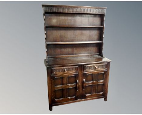 An Ercol elm and beech Welsh double door dresser in an antique finish.