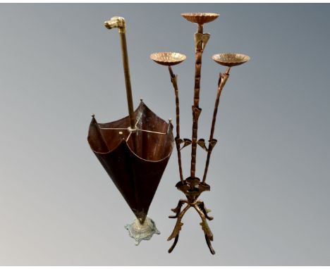 A brass dog's head stick pot in the form of an umbrella together with a metal three way candleholder.