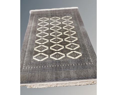 A Lahore Bokhara carpet, Pakistan, on cream ground with repeat lattice central field, 305 cm x 205 cm