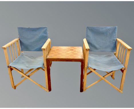 A pair of folding director's style chairs together with a two tier occasional table with chessboard top.