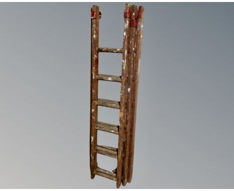 A vintage wooden three section extending ladder.