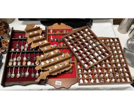 A large collection of ceramic thimbles &amp; tourist spoons on display racks