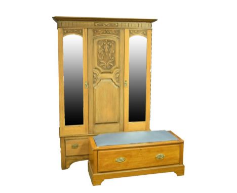 Edwardian stripped walnut wardrobe having carved central panel flanked by bevelled mirror panel doors and with one long drawe