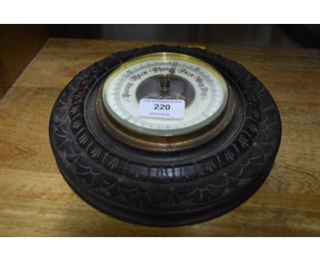 A carved oak circular barometer 