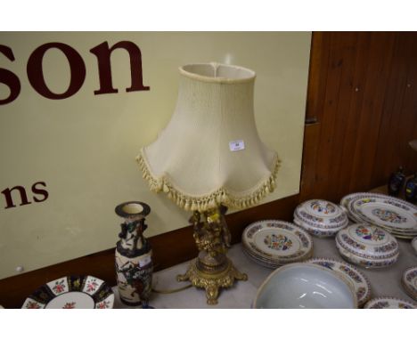 A brass figural mounted table lamp and shade 