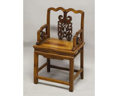 A CHINESE PIERCED AND CARVED WOODEN CHAIR, with shaped top rail and carved back section with a bat above fruit and leaves, su