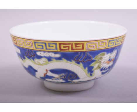 A SMALL CHINESE BLUE GLAZED PORCELAIN  DRAGON BOWL, the bowl exterior incised and painted with two dragons and the pearl of w