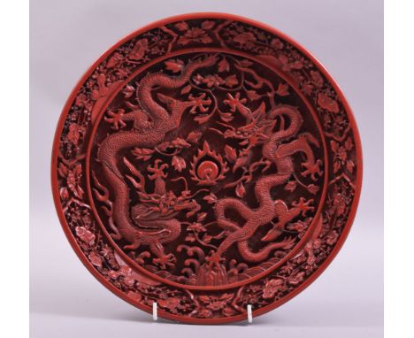 A GOOD CHINESE CINNABAR LACQUER DISH, the centre with two dragons and the flaming pearl of wisdom, 29.5cm diameter.