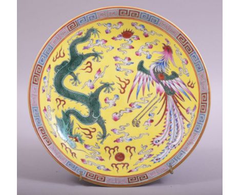 A CHINESE FAMILLE JAUNE PORCELAIN DISH, painted with greek key border, central with dragon and phoenix with the flaming pearl