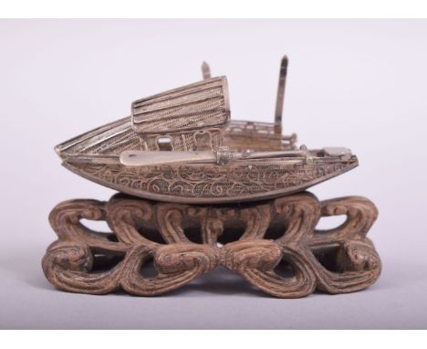 A SMALL CHINESE FILIGREE MODEL OF A JUNK, on a wooden stand, 7.5cm long.