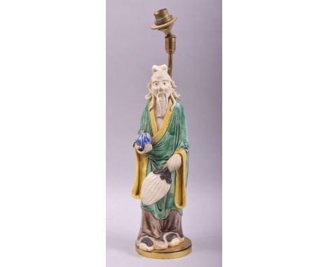 A CHINESE GREEN AND YELLOW PARTLY GLAZED POTTERY FIGURE mounted as a lamp, overall height 42cm high.