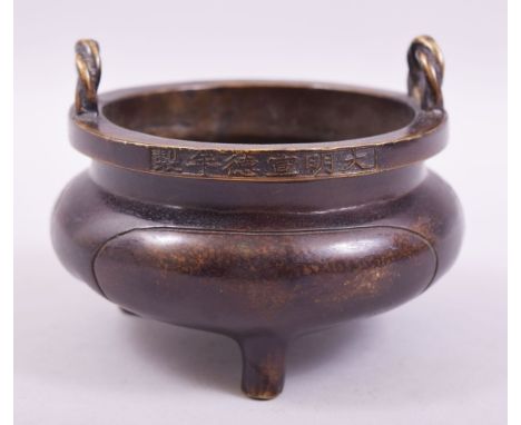 A CHINESE BRONZE TWIN HANDLE TRIPOD CENSER, with rope form handles, the rim with six character mark and the base with a symbo