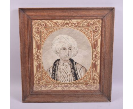 A WOOLWORK TAPESTRY BUST LENGTH PORTRAIT of a male Arab youth in a moulded oak frame, image size 32cm x 30cm.