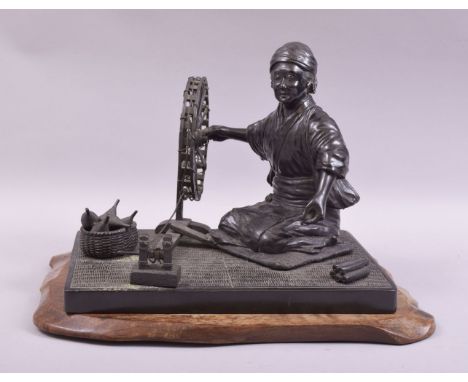 A GOOD JAPANESE BRONZE GROUP modelled as a lady kneeling beside a spinning wheel with a basket of yarn, together with a hardw