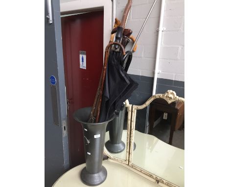 A stick stand and quantity of walking sticks and umbrellas 