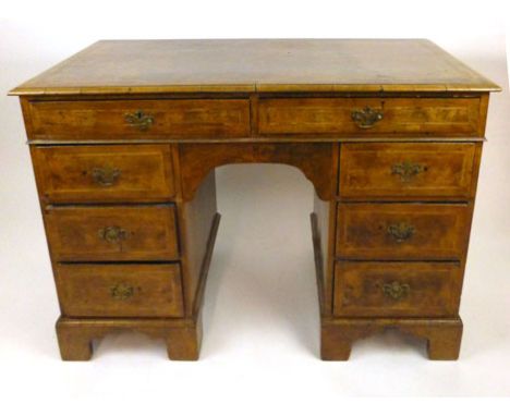 An early 18th century style walnut twin pedestal desk, the book matched veneered and crossbanded top over two long drawers ab