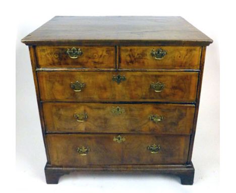 An early 18th century walnut chest of two over three drawers, the quarter veneered crossbanded top over crossbanded drawers o