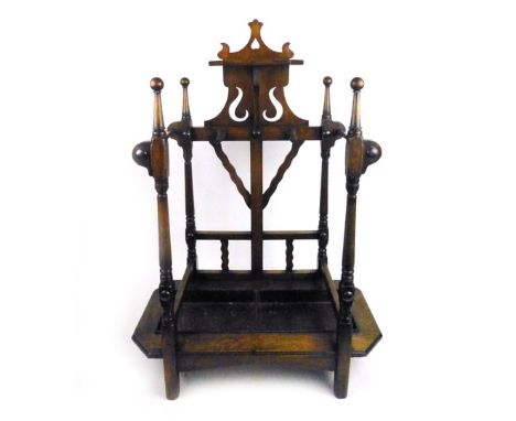 An Edwardian oak stick/umbrella stand with pierced shelf back and turned supports over original drip tray. h. 93 cm, w. 66 cm