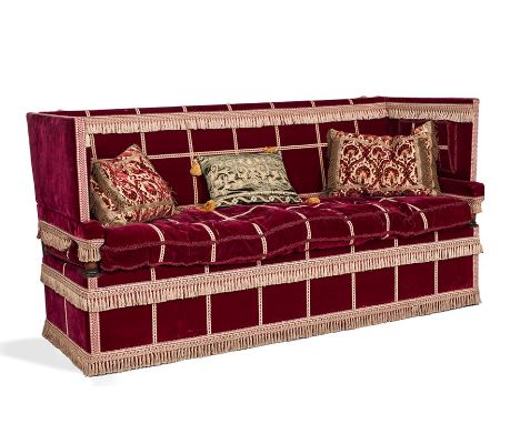 A large Knole sofa, late 20th Century
Upholstered in tasselled red velvet, oak framed and on brass castors, 202cm wide, 75cm 