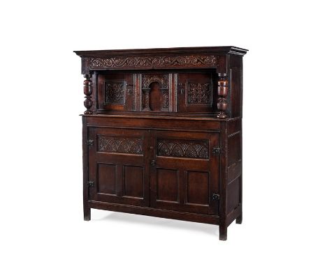 A Charles I oak press cupboard, circa 1640
Carved with scrolls, strapwork and lunettes, enclosed by a pair of upper doors eit