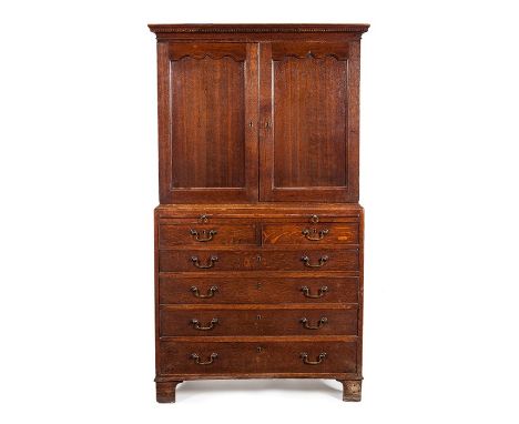 A George III oak Estate cupboard, circa 1780
With dentil-moulded cornice and a pair of pointed ogee panel doors enclosing twe