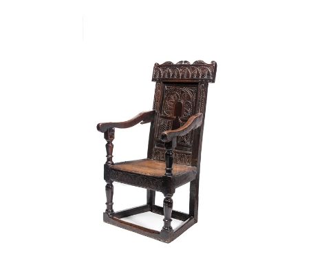 A Charles I oak armchair, West Country, circa 1640
The back panel carved with a foliate arcade flanked by stiff leaf uprights
