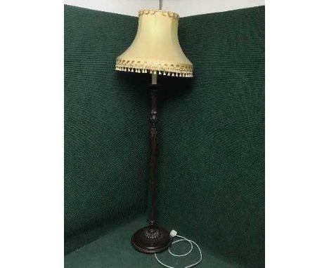 A carved mahogany standard lamp and shade 