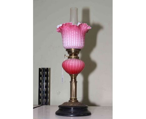 Victorian oil lamp with opaque ruby glass reservoir and fluted shade, 43cm to top of shade.