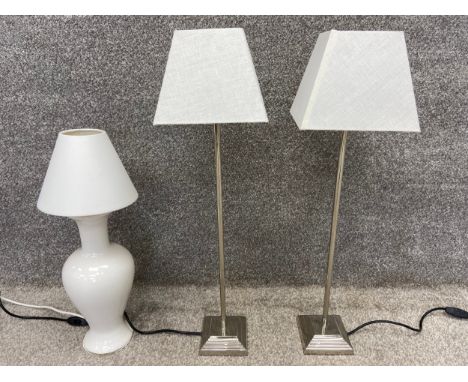 A pair of contemporary chrome table lamps with shades, along with a ceramic baluster vase lamp with shade. H.74cm (largest).