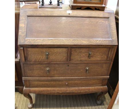 A MID-CENTURY OAK FINISHED BUREAU with fall down writing slop, revealing compartmentalised interior over two inline drawers, 